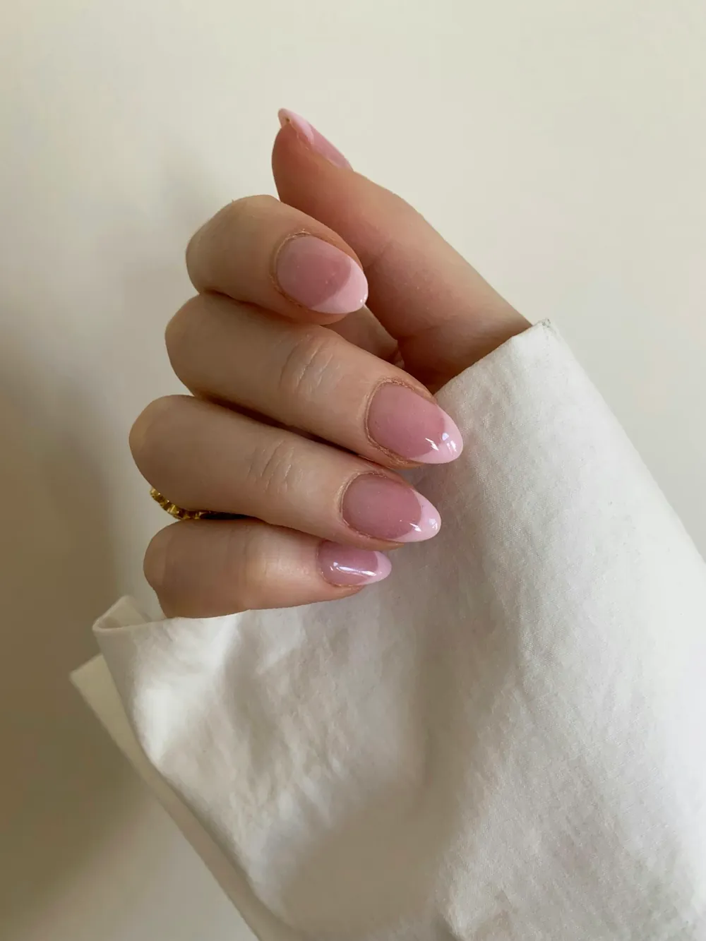 Manicura rosa pálido con brillo sobre un pañuelo blanco